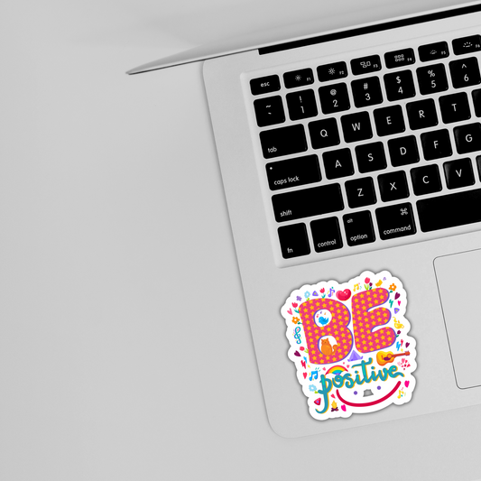 Colorful 'Be Positive' sticker on silver laptop keyboard, cute trendy sticker design