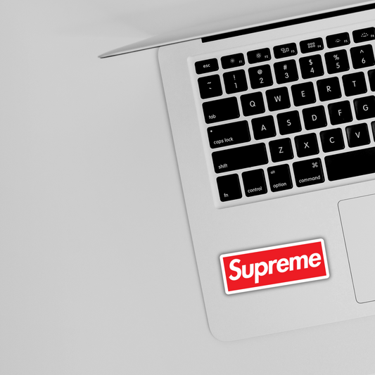 Red Supreme logo sticker on silver laptop, trendy vinyl decal from Sticksnap sticker shop